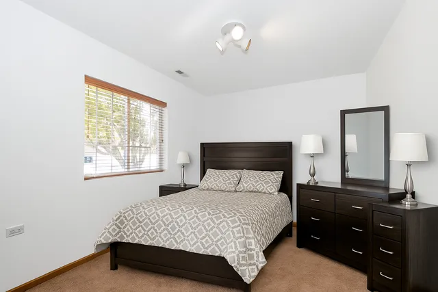 a bedroom with a bed and a night stand