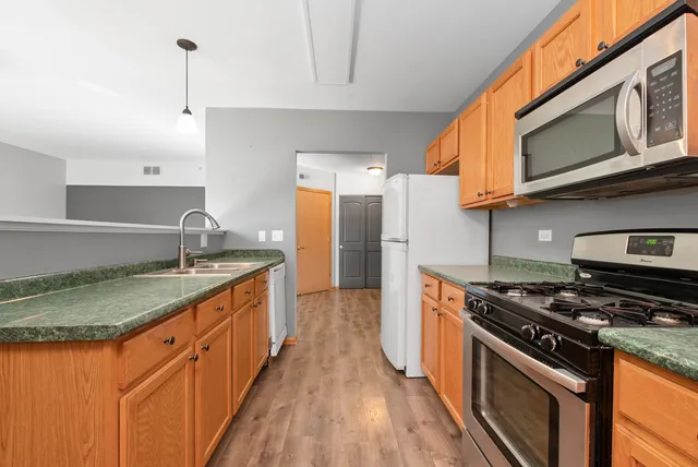 a kitchen with stainless steel appliances granite countertop a stove a sink and a refrigerator