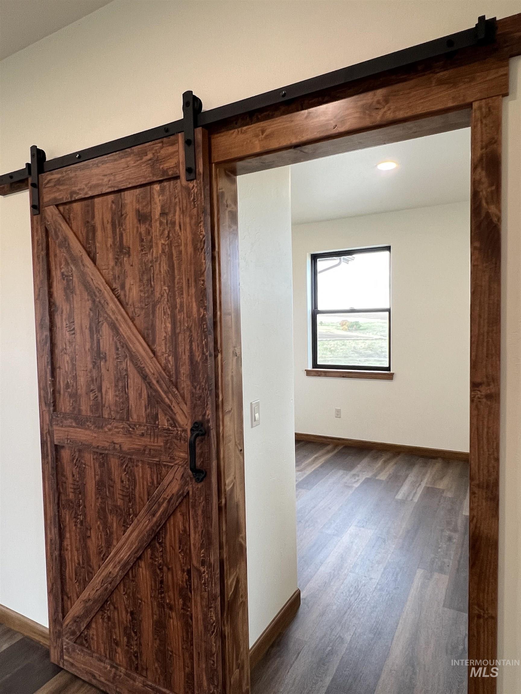 137 Angus Ranch Grangeville, ID 83530 - Photo 7 of 32 Corridor featuring a barn door and dark wood-style flooring