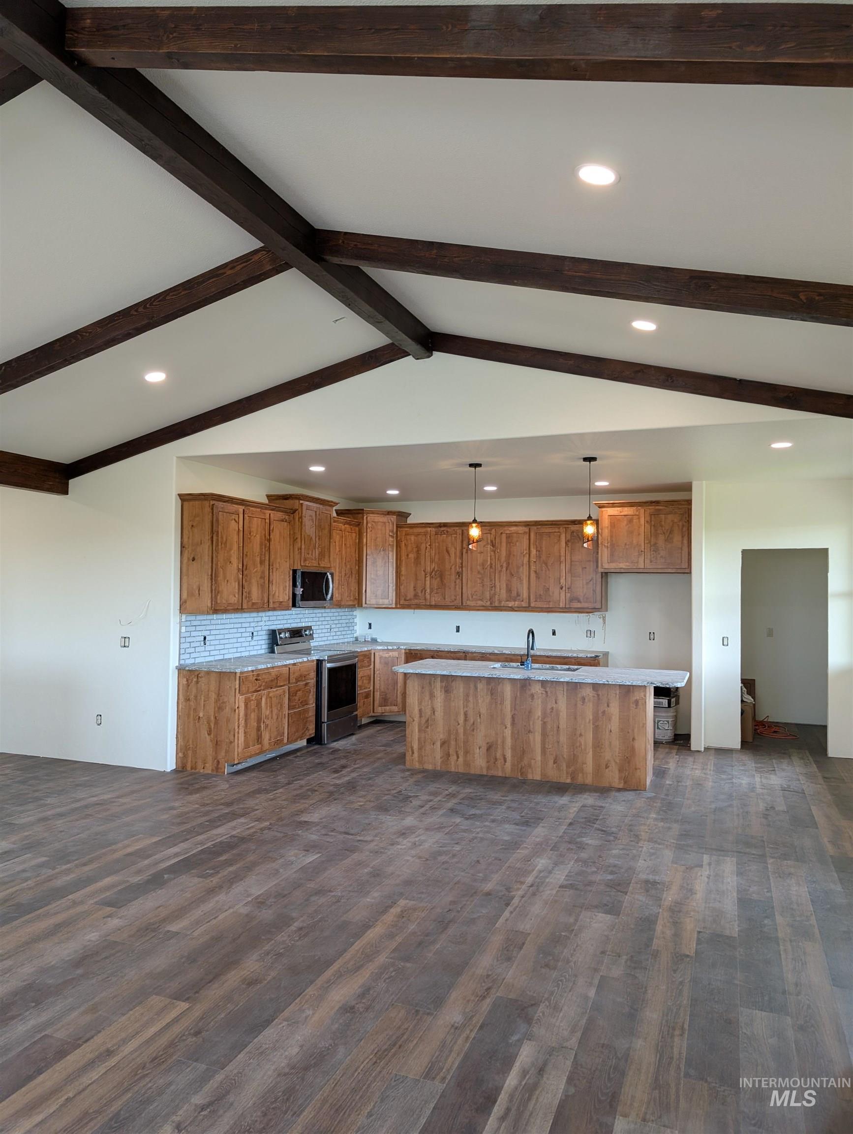 137 Angus Ranch Grangeville, ID 83530 - Photo 9 of 32 Kitchen with recessed lighting, brown cabinetry, hanging light fixtures, appliances with stainless steel finishes, and a center island with sink