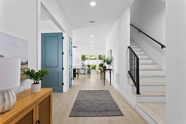 a living room with furniture a large window and a view of kitchen