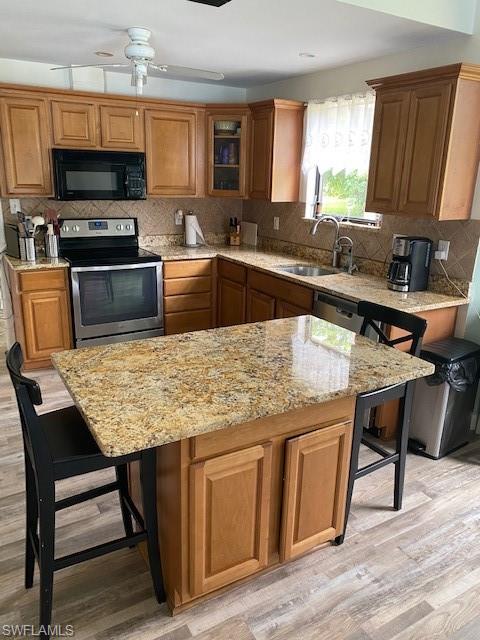 6560 Bottlebrush Lane Naples, FL 34109 - Photo 4 of 4 a kitchen with a stove a sink a microwave and wooden cabinets