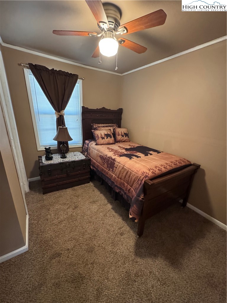 84 Avery High School Road Newland, NC 28657 - Photo 10 of 29 a bedroom with a bed and a chandelier