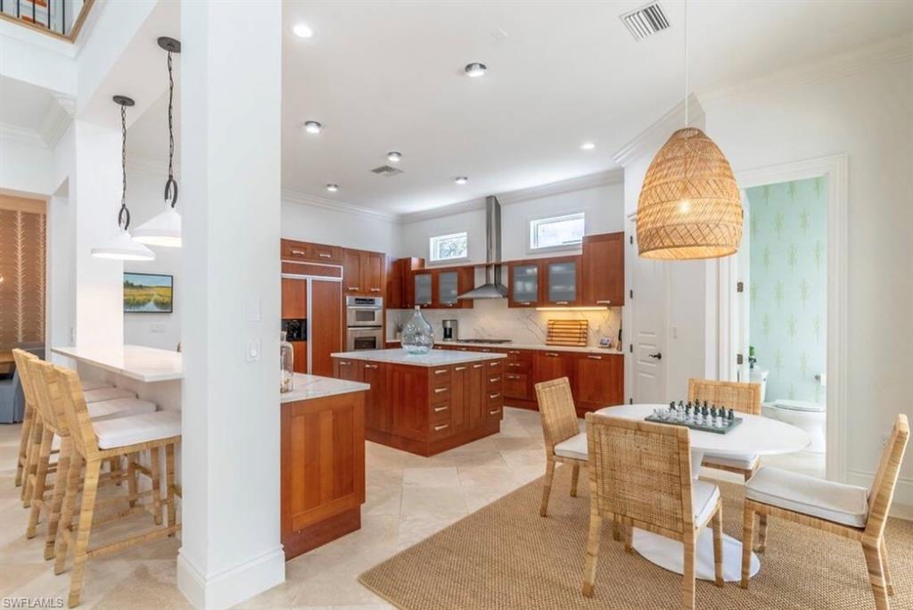 428 Rudder Road Naples, FL 34102 - Photo 15 of 49 a large kitchen with a table and chairs in it