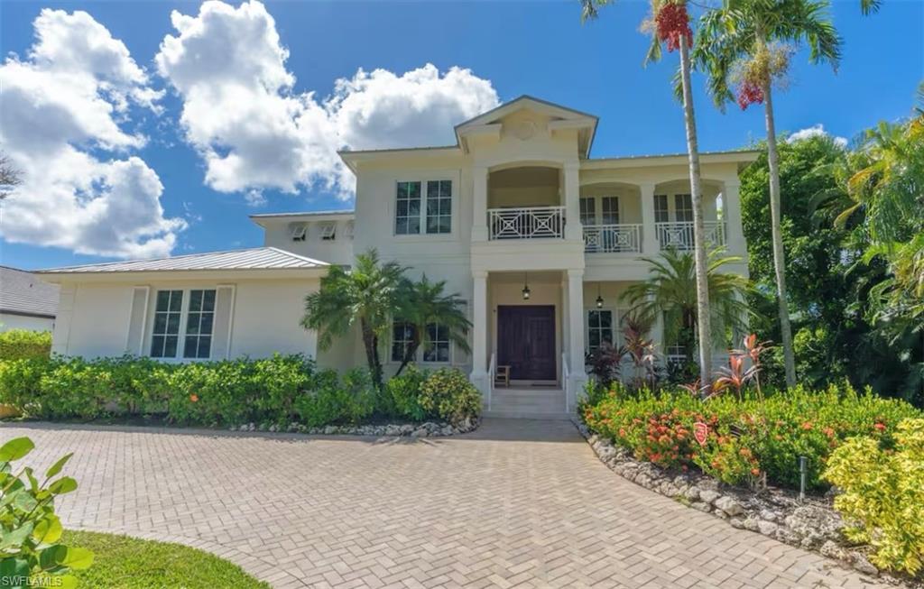 428 Rudder Road Naples, FL 34102 - Photo 2 of 49 a front view of a house with a garden