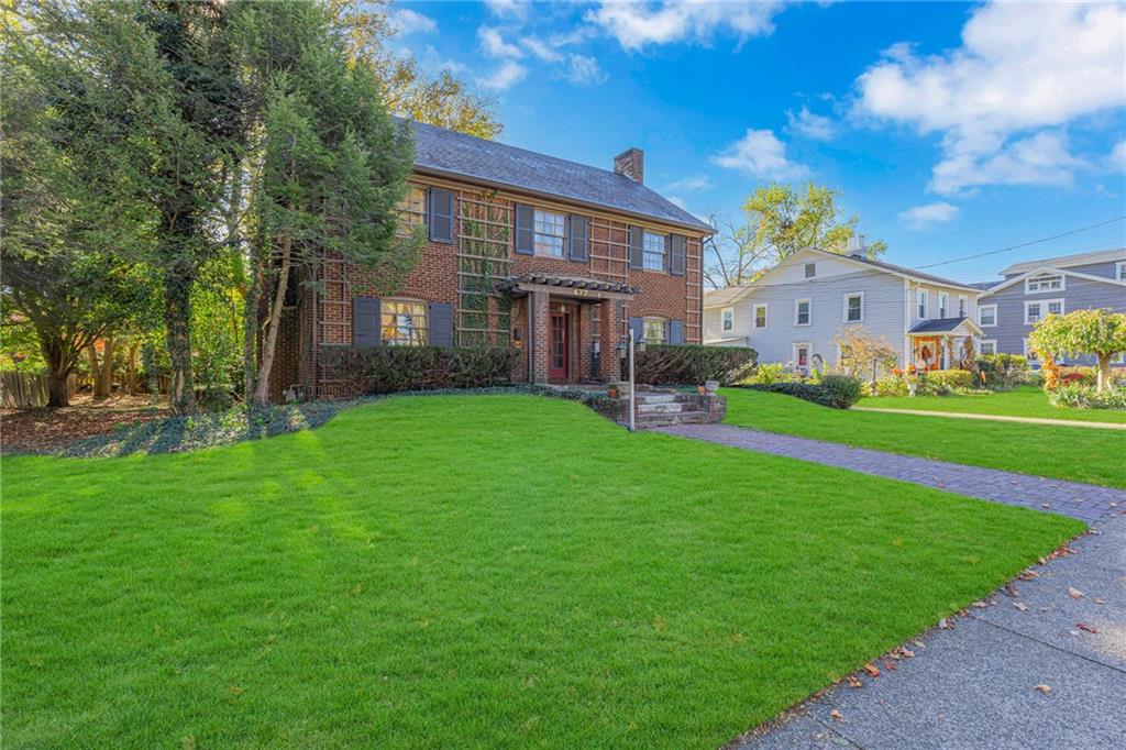 a view of a big house with a big yard and large tree