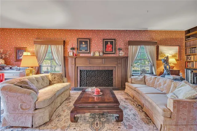 a living room with furniture a large window and a fireplace