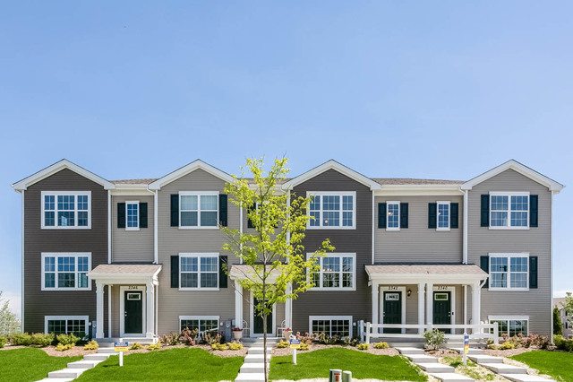 a front view of a building with yard and trees