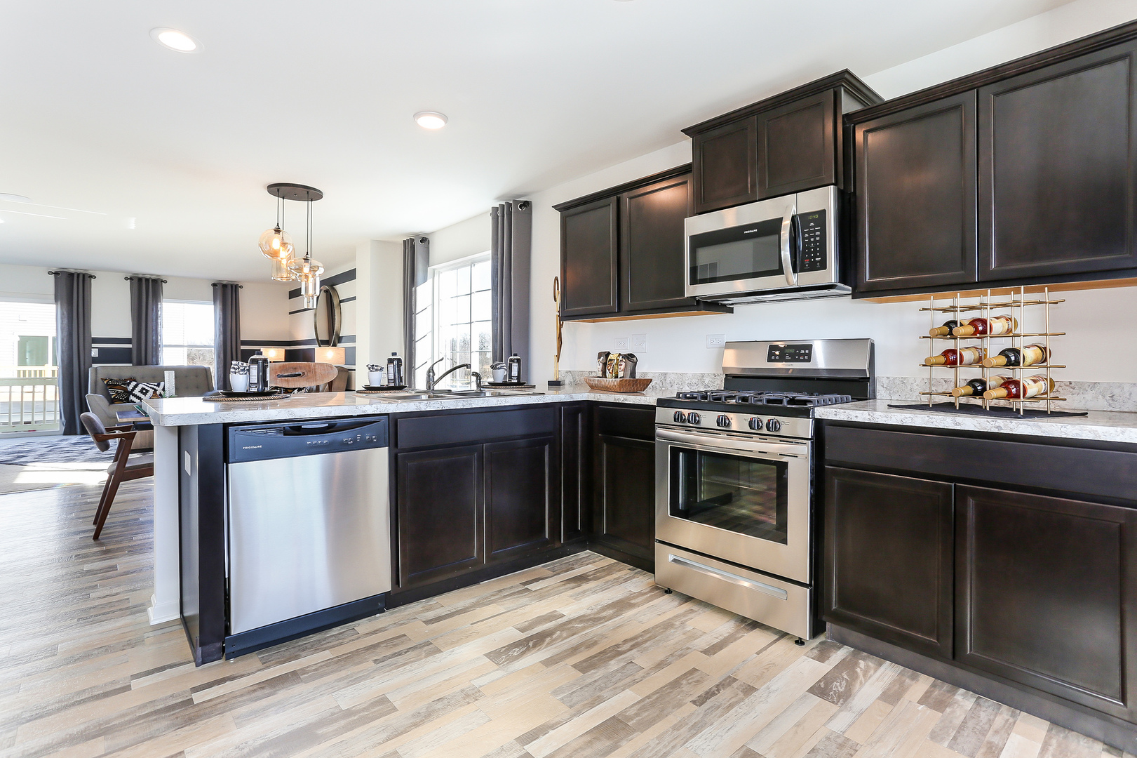 2472 Bella Drive, Unit 2575 Pingree Grove, IL 60140 - Photo 3 of 29 a kitchen with stainless steel appliances kitchen island granite countertop a stove a sink and a microwave
