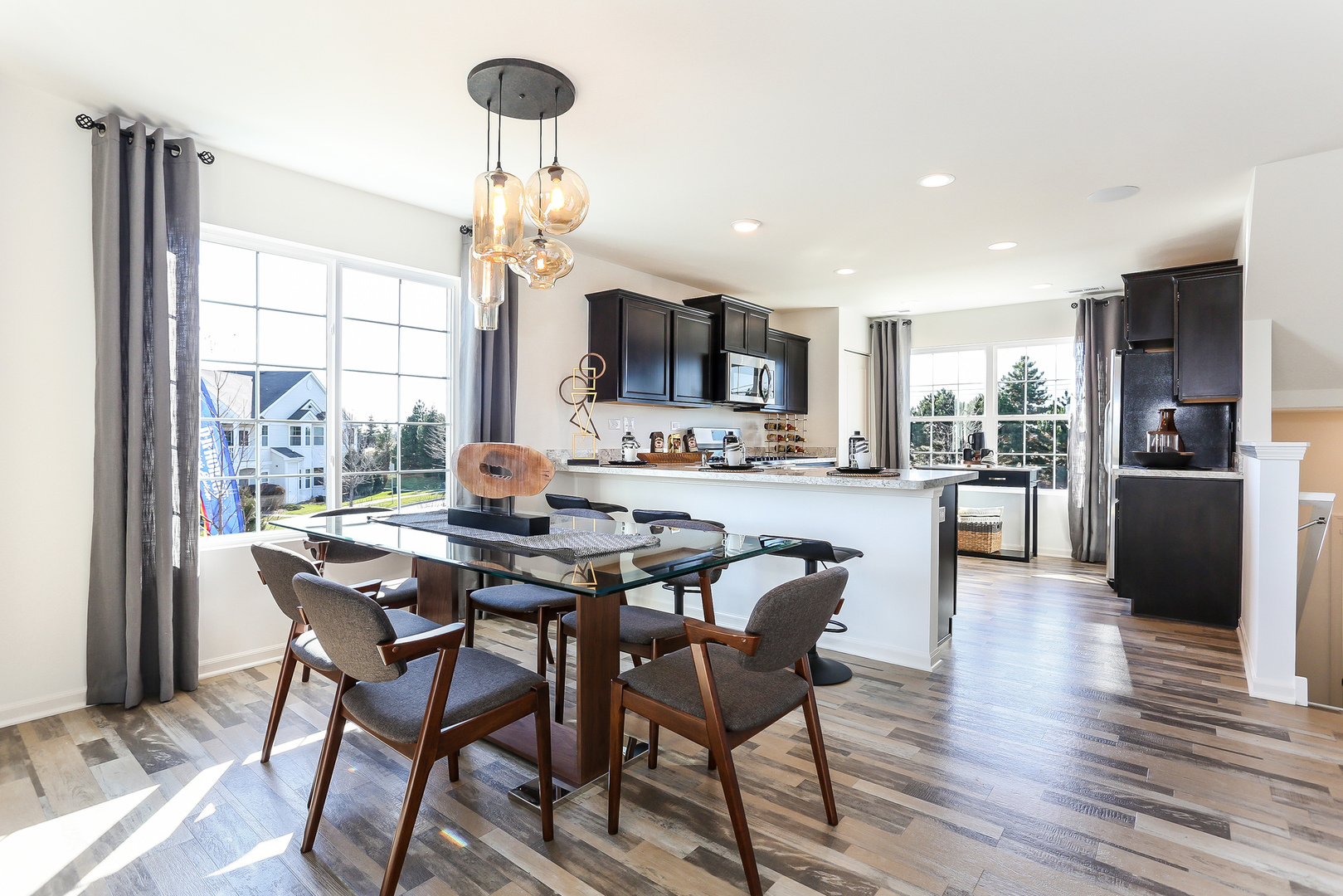 2472 Bella Drive, Unit 2575 Pingree Grove, IL 60140 - Photo 5 of 29 a view of a dining room with furniture a chandelier and wooden floor