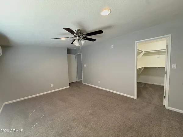 an empty room with a ceiling fan and a window