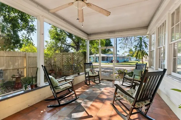 a living room with patio furniture and a floor to ceiling window