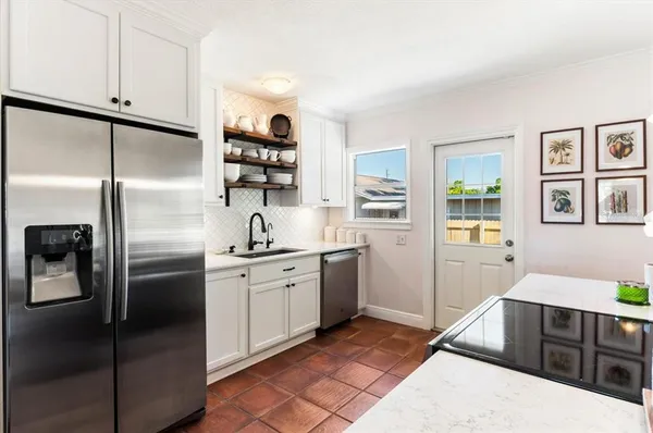 a kitchen with stainless steel appliances granite countertop a refrigerator and a stove top oven
