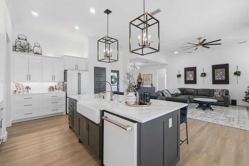 136 Mistletoe Ridge Lawn, TX 79530 - Photo 12 of 37 Kitchen with white cabinetry, a breakfast bar, pendant lighting, light stone counters, and crown molding