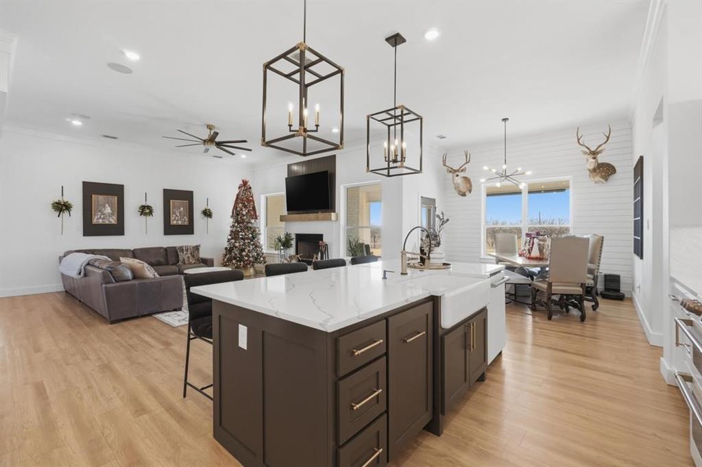 136 Mistletoe Ridge Lawn, TX 79530 - Photo 37 of 37 Kitchen featuring dark brown cabinets, a fireplace, a kitchen breakfast bar, open floor plan, and recessed lighting
