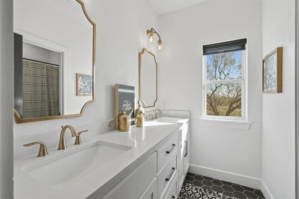136 Mistletoe Ridge Lawn, TX 79530 - Photo 18 of 37 Full bath featuring double vanity, dark tile patterned flooring, and a shower with shower curtain