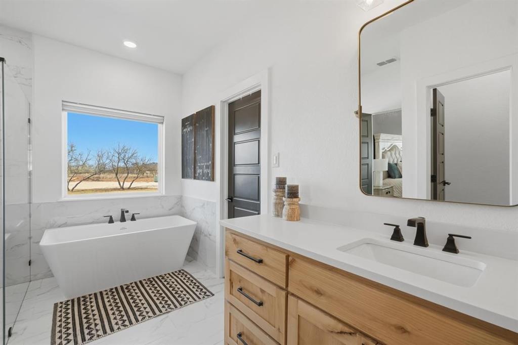 136 Mistletoe Ridge Lawn, TX 79530 - Photo 27 of 37 Bathroom featuring a freestanding tub, a wainscoted wall, light marble finish floors, tile walls, and vanity