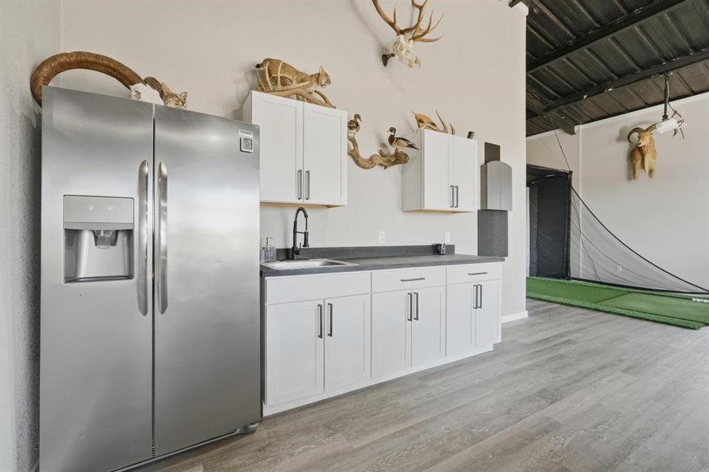 136 Mistletoe Ridge Lawn, TX 79530 - Photo 34 of 37 Kitchen with white cabinets, light wood-type flooring, dark countertops, and a towering ceiling