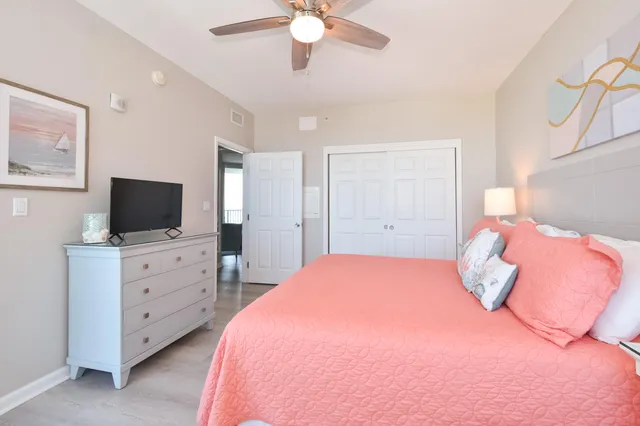 a bedroom with a large bed and a flat tv screen on dresser