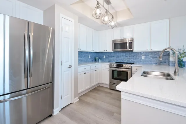 a kitchen with stainless steel appliances a refrigerator sink and cabinets