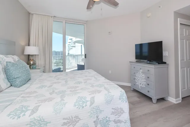 a bedroom with a large bed and a flat tv screen on dresser