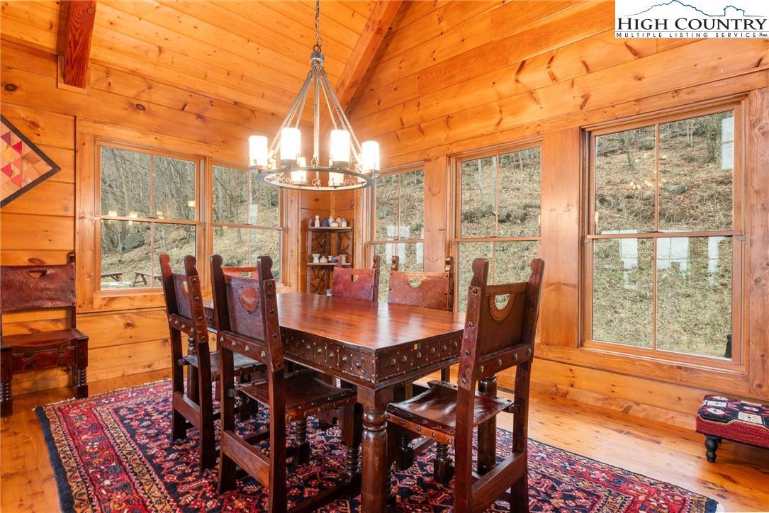 635 Acorn Road Zionville, NC 28698 - Photo 14 of 50 a dining room with furniture a rug and a floor to ceiling window