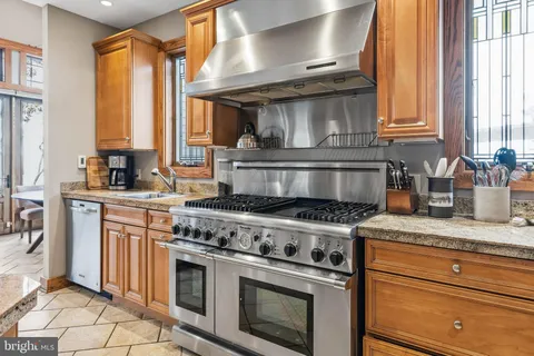 a kitchen with stainless steel appliances granite countertop a stove a sink and a refrigerator