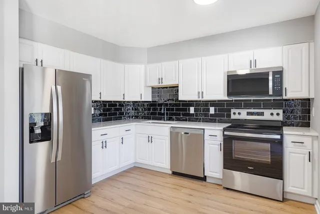 a kitchen with stainless steel appliances a refrigerator stove and microwave