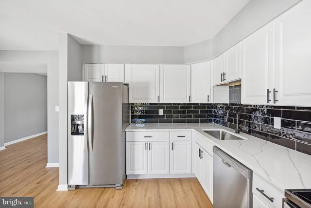 a kitchen with a sink a refrigerator a microwave and cabinets