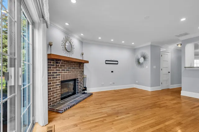 a view of empty room with wooden floor and fireplace