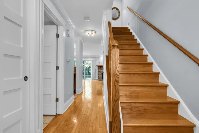 a view of a hallway with wooden floor and staircase