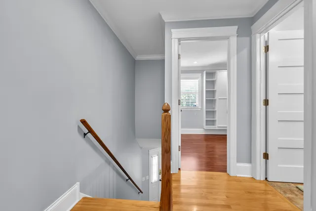 a view of a hallway with wooden floor and staircase