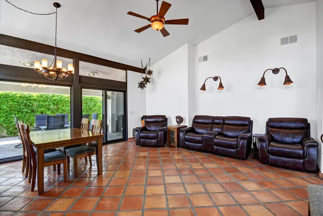 a spacious bedroom with a bed a dresser and a chandelier