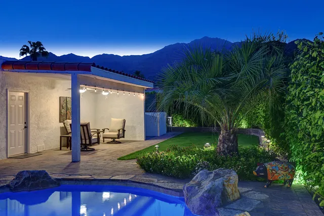 a view of a dining room with furniture one side kitchen view and wooden floor