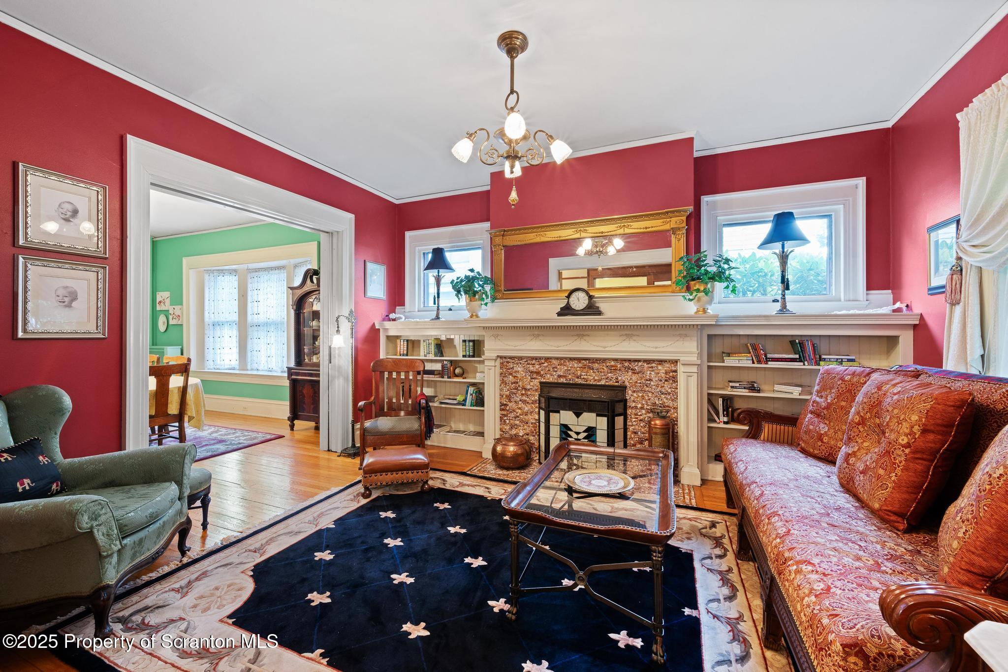 1012 Sunset Street Scranton, PA 18509 - Photo 10 of 46 a living room with furniture a fireplace and a chandelier