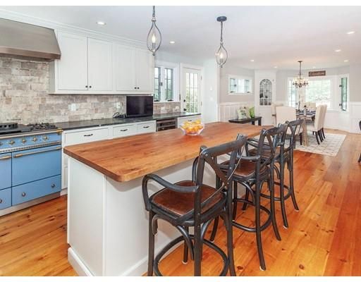 an open kitchen with granite countertop a stove a sink a counter top space and cabinets
