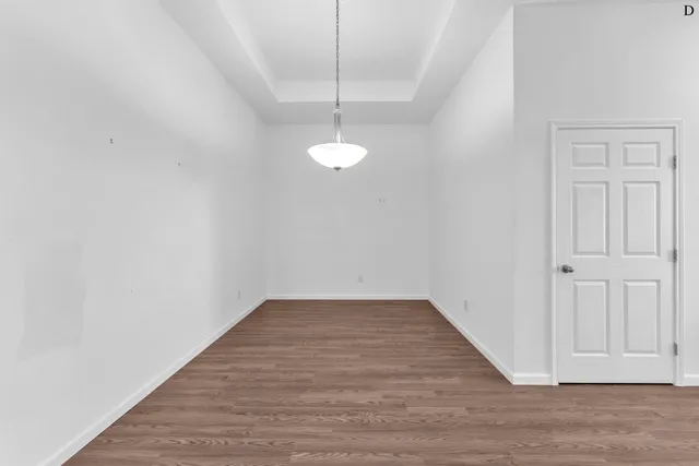 a view of a room with wooden floor and white walls