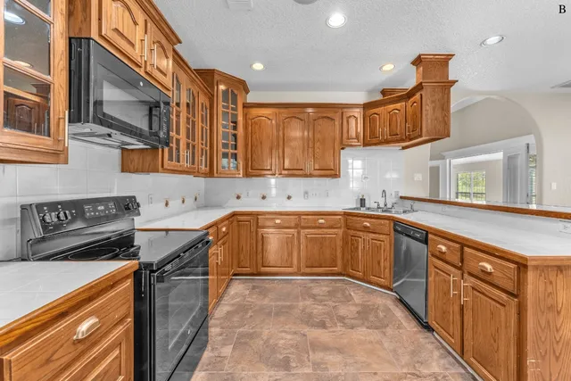 a kitchen with stainless steel appliances sink stove and cabinets