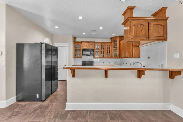 a kitchen with stainless steel appliances granite countertop a refrigerator and a sink