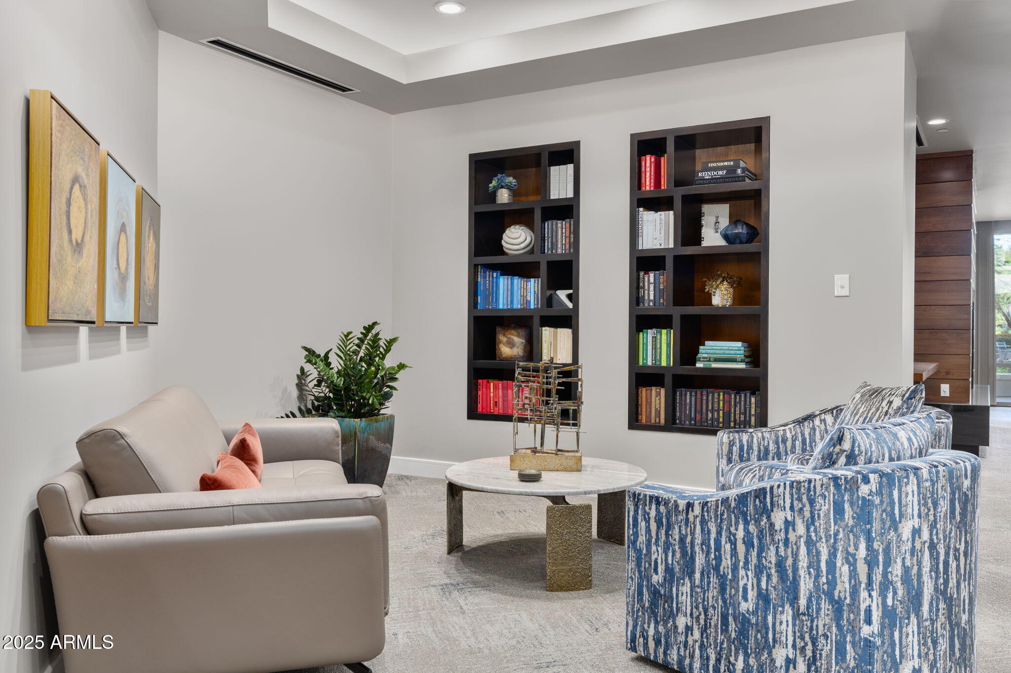 2211 East Camelback Road, Unit 201 Phoenix, AZ 85016 - Photo 29 of 42 a living room with furniture a bookshelf and a potted plant