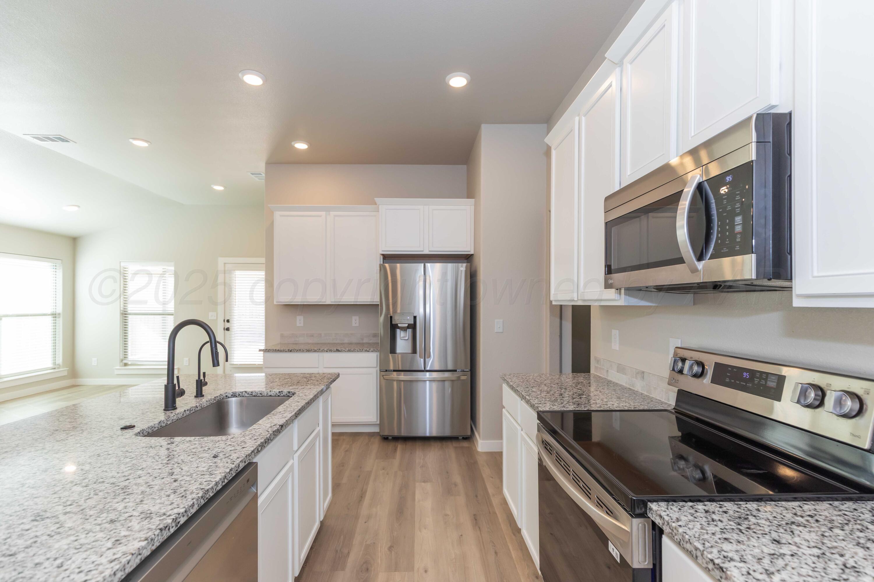1801 Moon River Road Amarillo, TX 79118 - Photo 11 of 43 a kitchen with stainless steel appliances granite countertop a sink stove and refrigerator