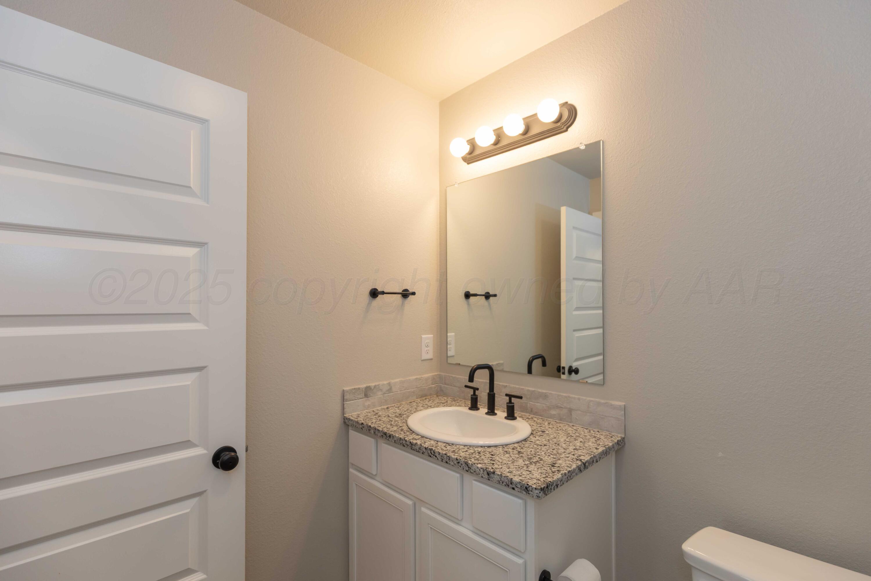 1801 Moon River Road Amarillo, TX 79118 - Photo 22 of 43 a bathroom with a granite countertop sink and a mirror