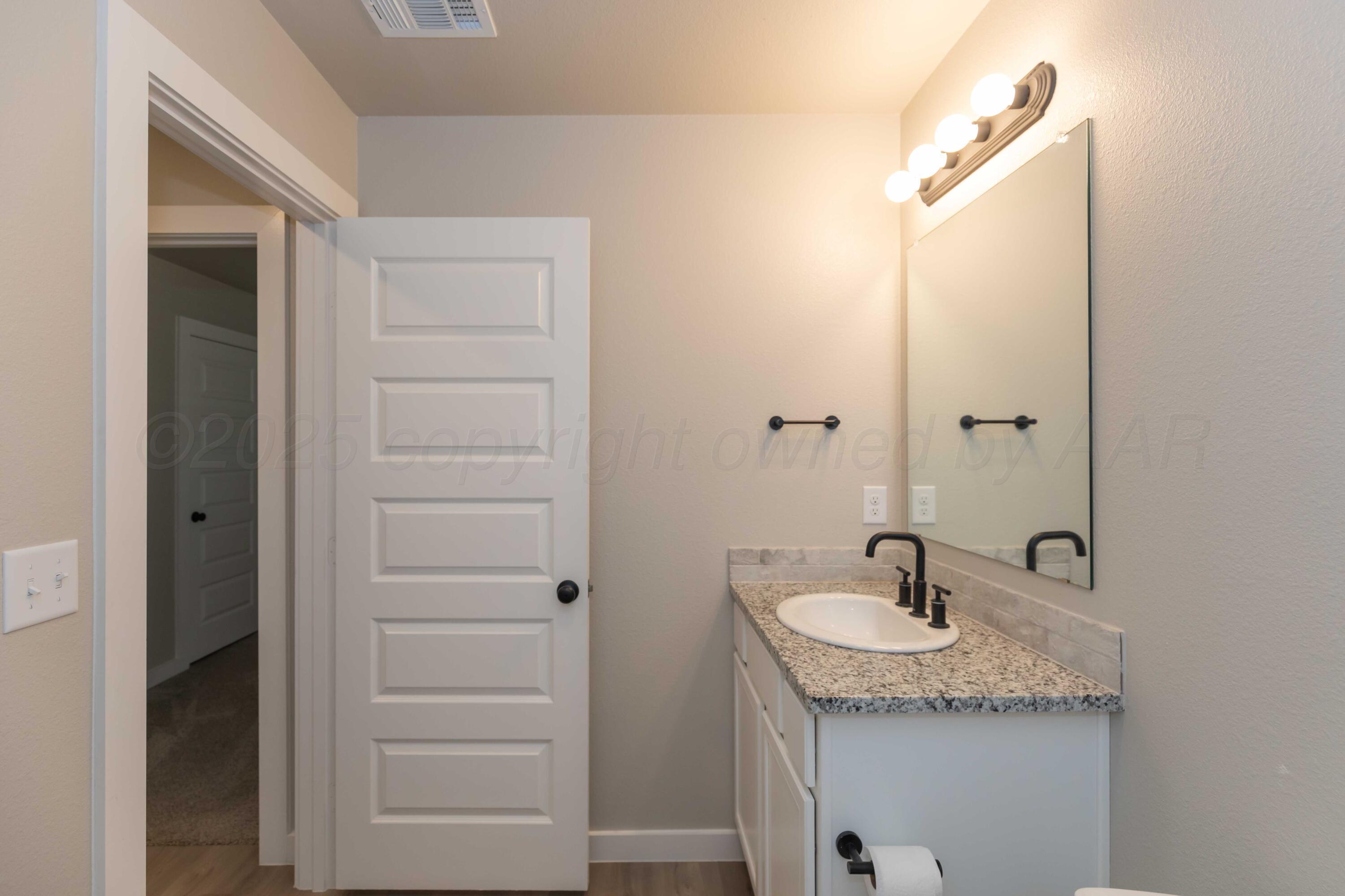 1801 Moon River Road Amarillo, TX 79118 - Photo 23 of 43 a bathroom with a granite countertop sink and a mirror
