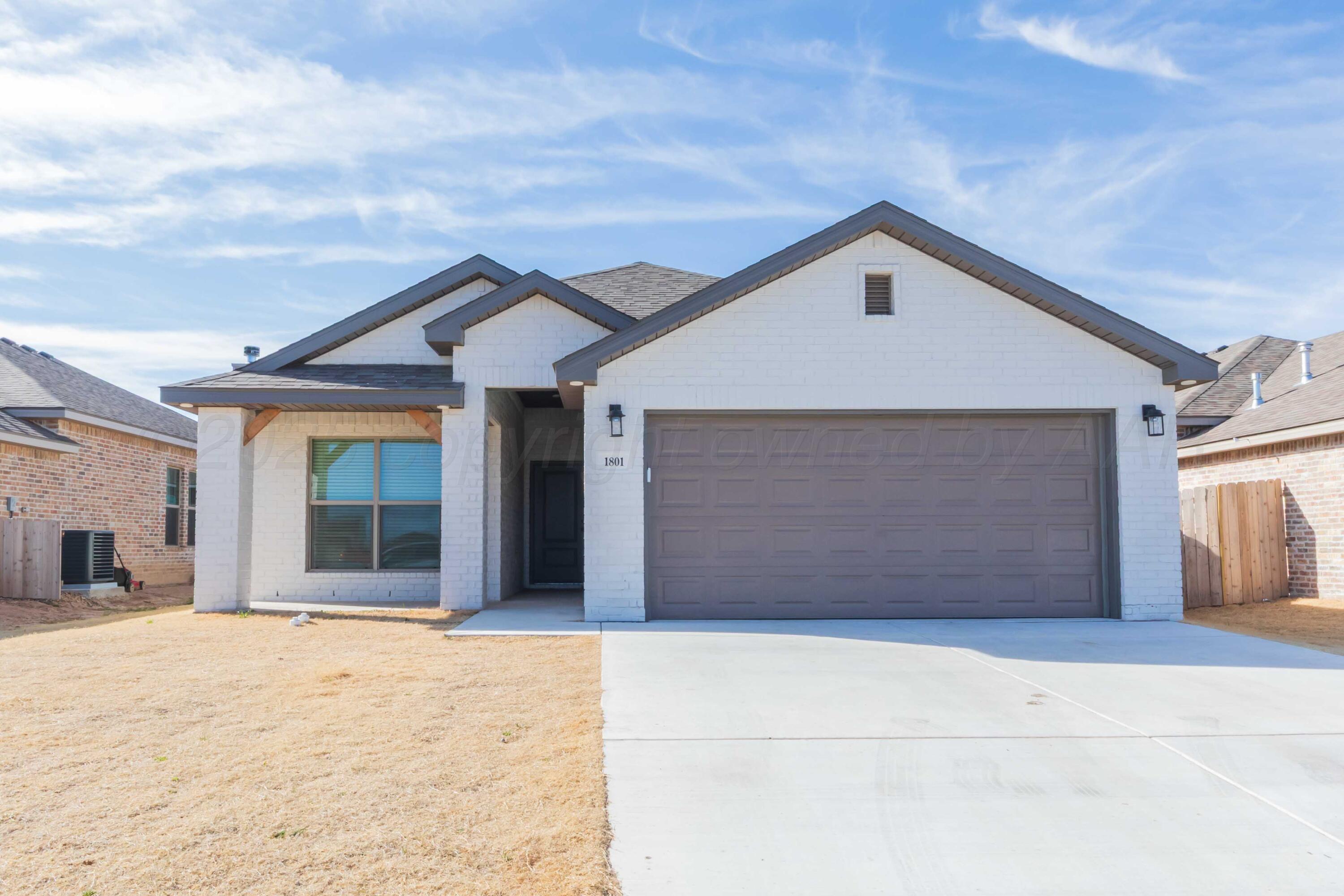 1801 Moon River Road Amarillo, TX 79118 - Photo 3 of 43 a front view of a house with a yard and garage