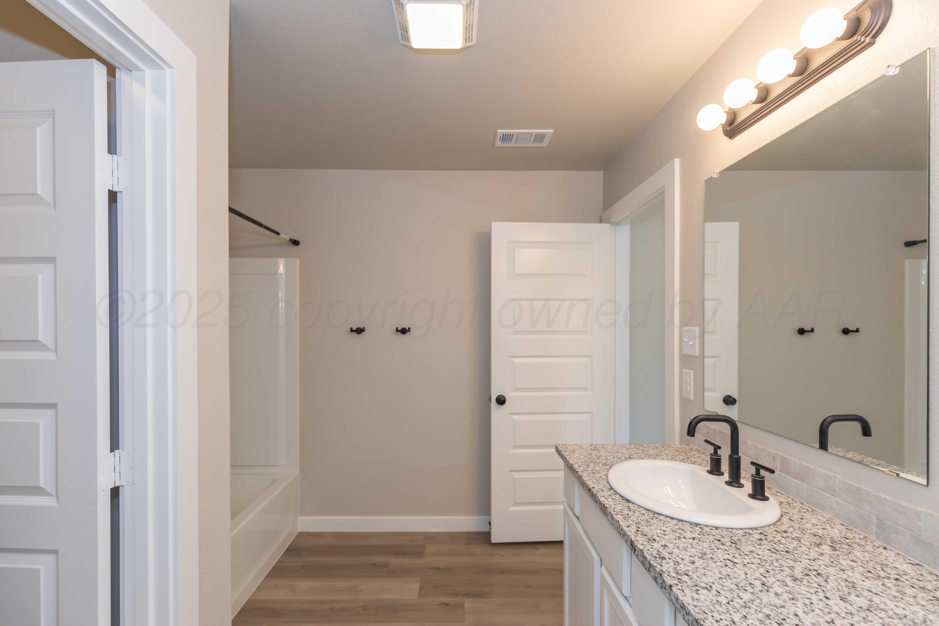 1801 Moon River Road Amarillo, TX 79118 - Photo 34 of 43 a bathroom with a granite countertop sink and a mirror