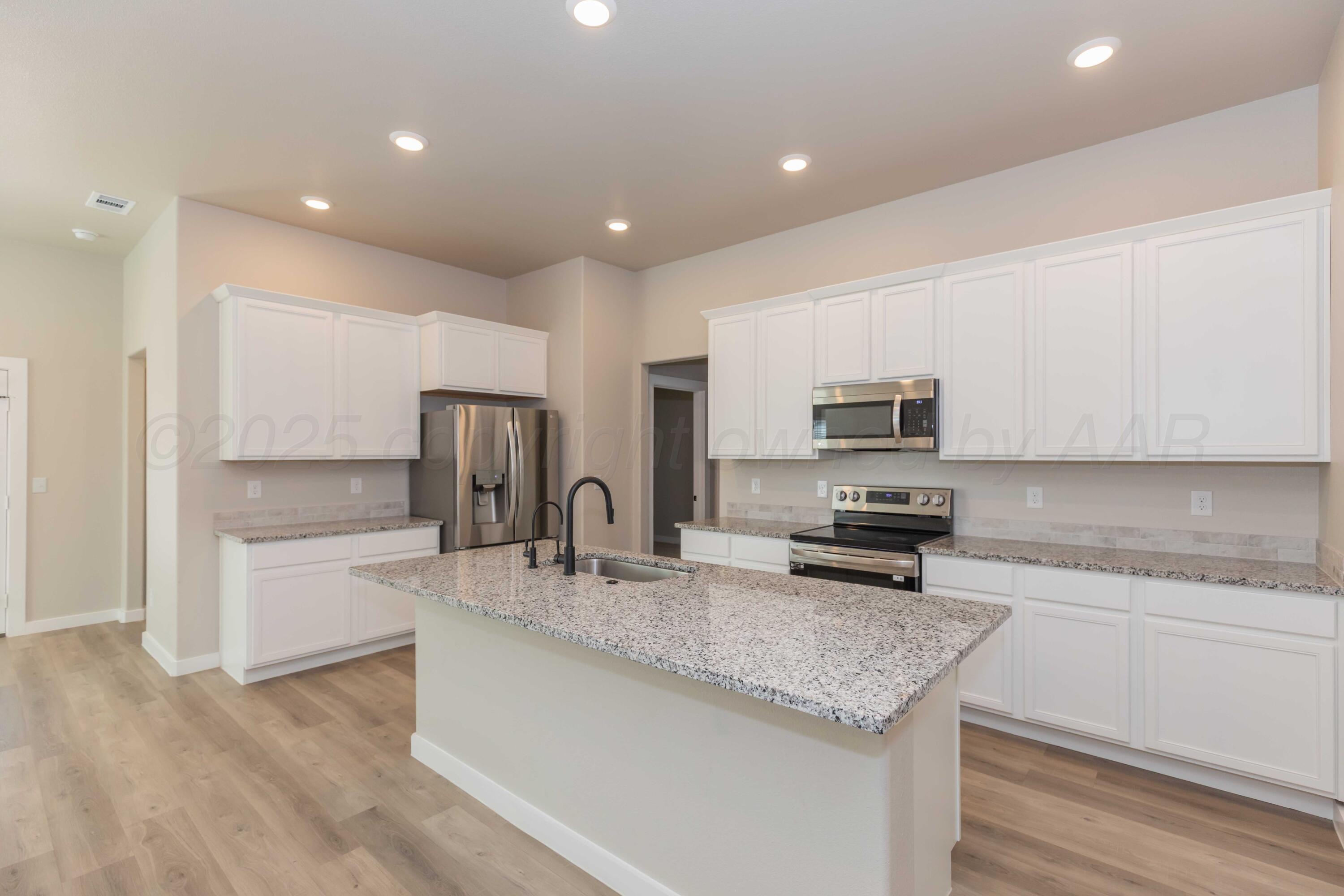 1801 Moon River Road Amarillo, TX 79118 - Photo 9 of 43 a kitchen with stainless steel appliances granite countertop a sink refrigerator and microwave