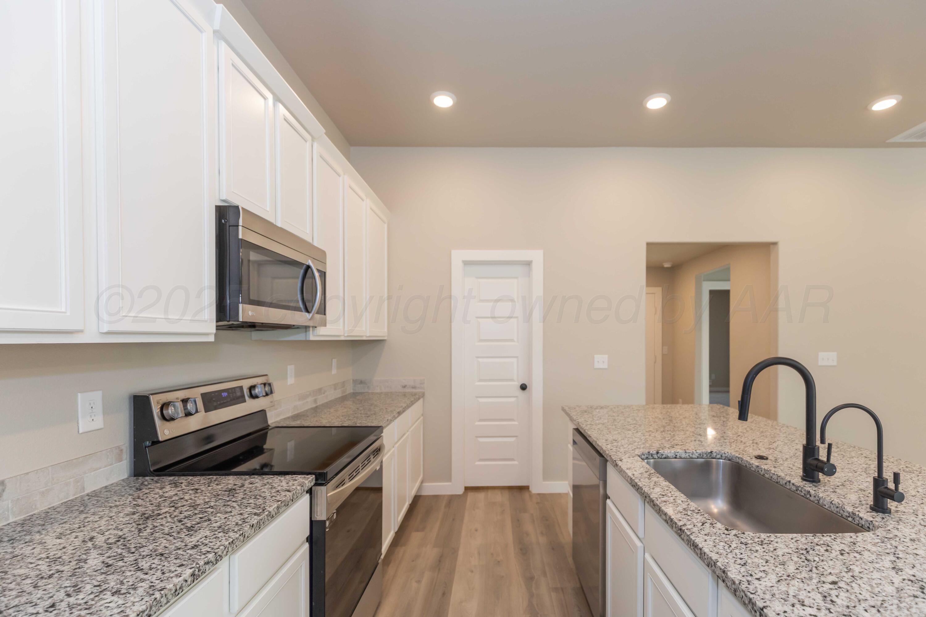 1801 Moon River Road Amarillo, TX 79118 - Photo 10 of 43 a kitchen with stainless steel appliances granite countertop a sink stove and cabinets
