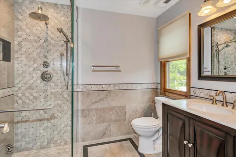 a bathroom with a sink a toilet and shower