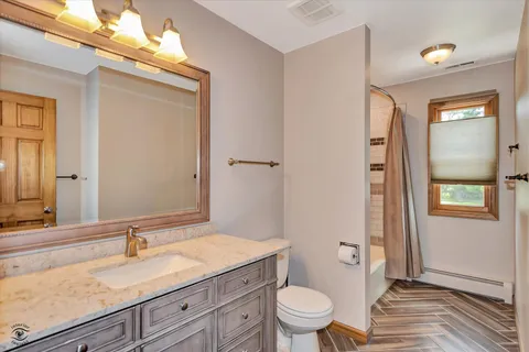 a bathroom with a granite countertop sink toilet and shower