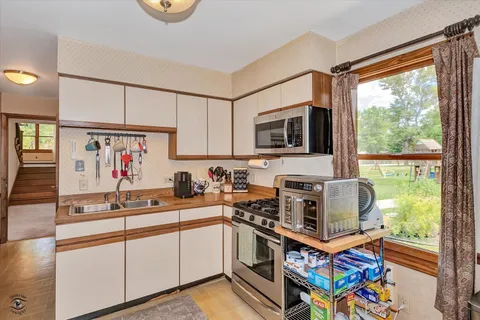 a kitchen with stainless steel appliances a stove a sink and a microwave